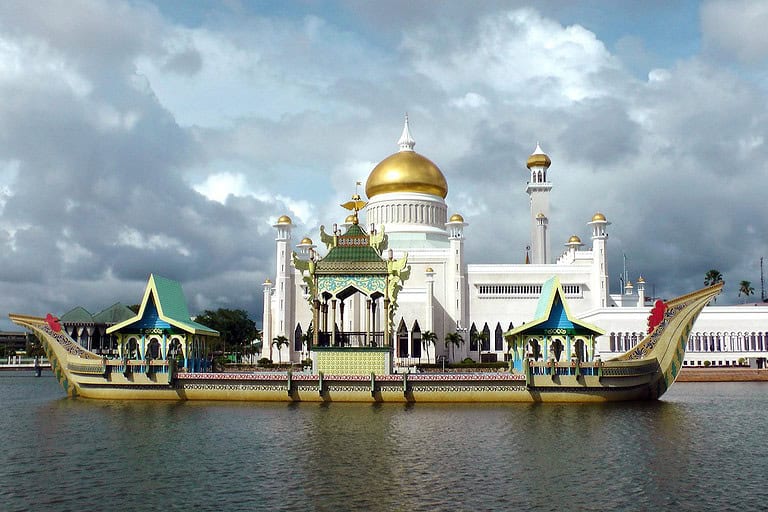 Golden dome mosque with ornate boat