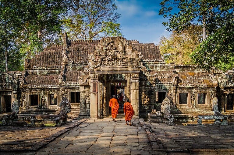 Monks walking towards ancient temple entrance